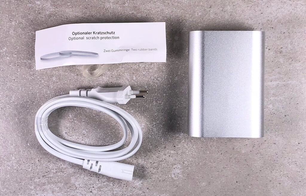 Im Lieferumfang des USB-C Netzteils von Artwizz sind neben dem Ladekabel auch zwei Gummibänder enthalten, die das Gehäuse vor Kratzern schützen sollen. Eine entsprechende Anleitung zur Verwendung liegt bei.